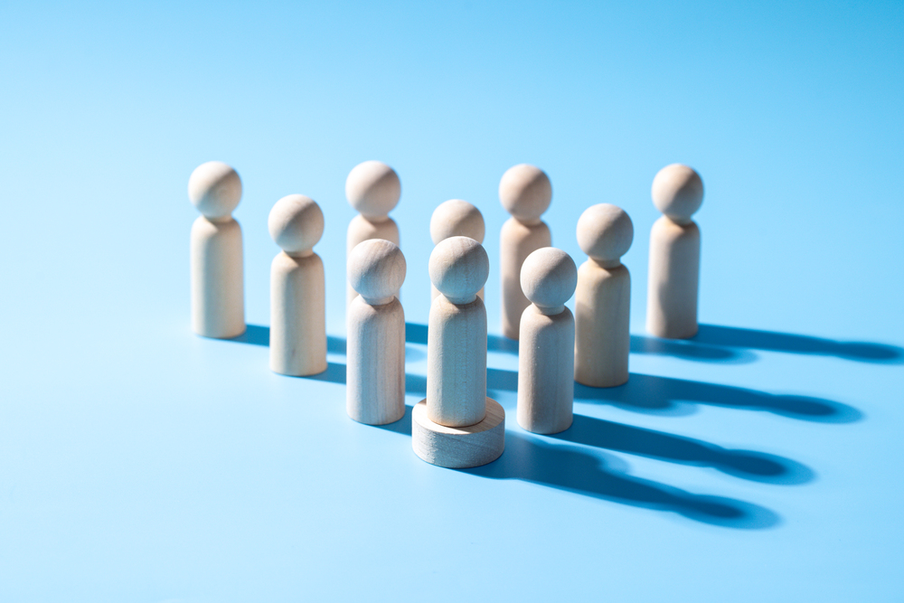 A wooden business teamwork symbol. Leadership styles concept of strategy cooperation. A group of employee from the company. The wooden symbol with light blue background. Professional business group.