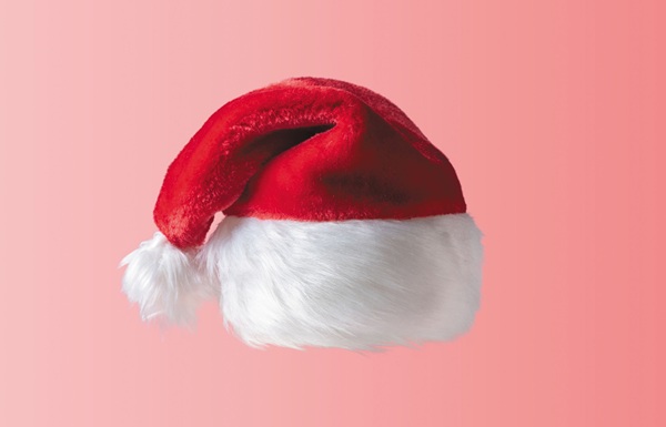 White hipster mustache and hat of Santa Claus on pink background. New Year or Christmas minimal concept.